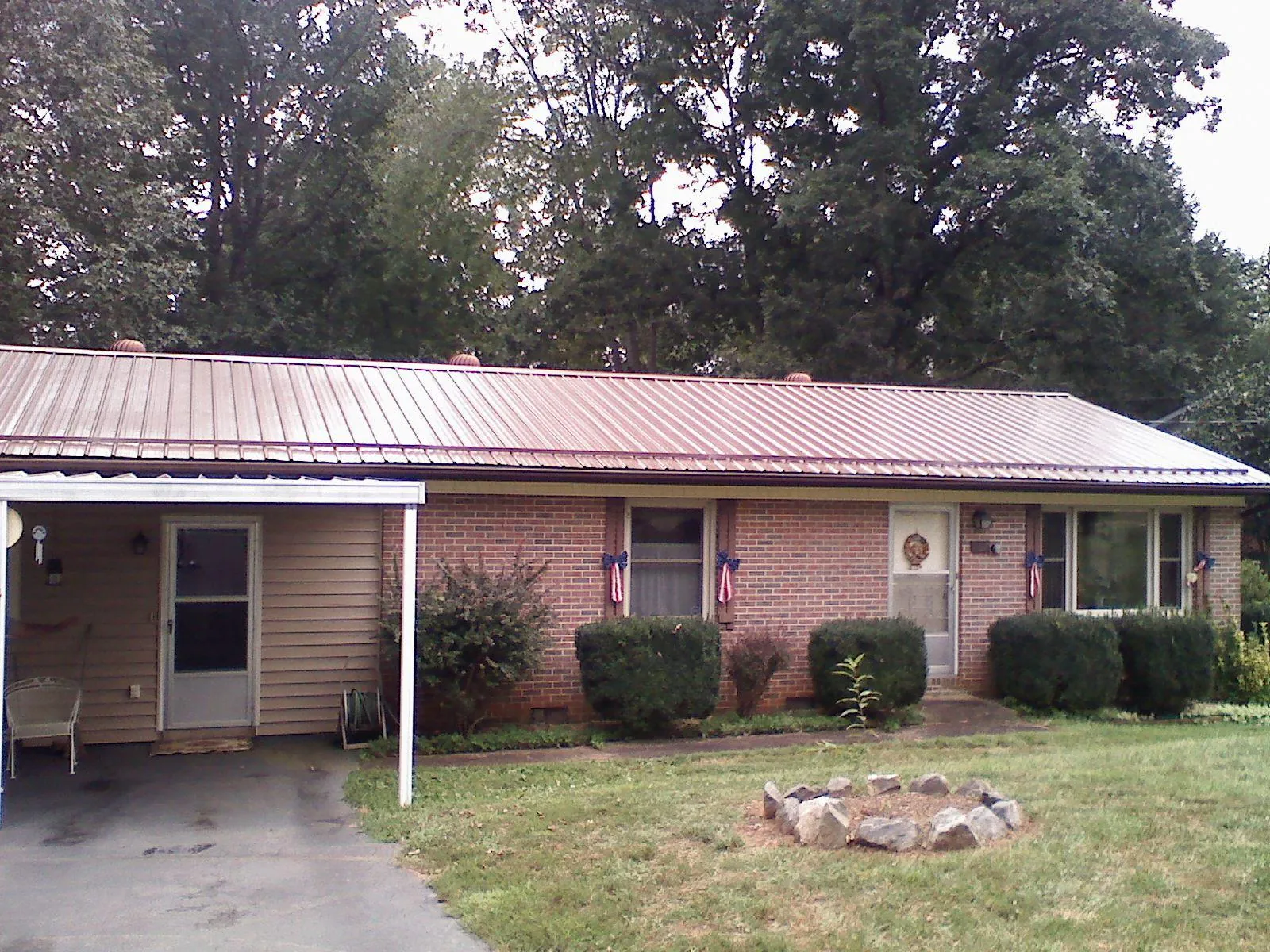 Bronze metal roof and carport on a brick ranch home — Roof Repair work by our crew in Wexford